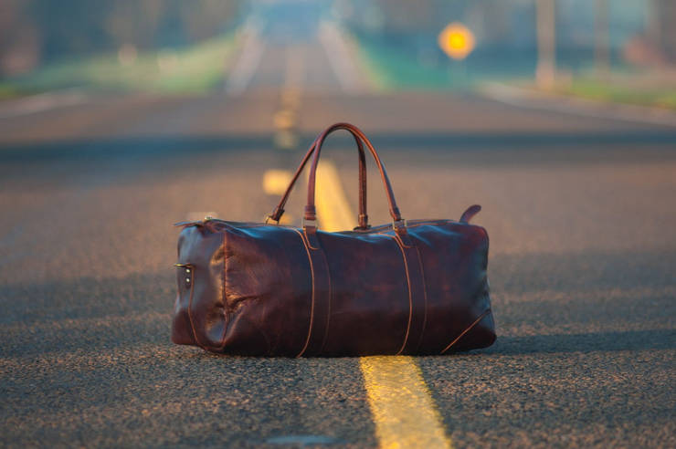 Leaving - Photo of a suitcase in the middle of a road